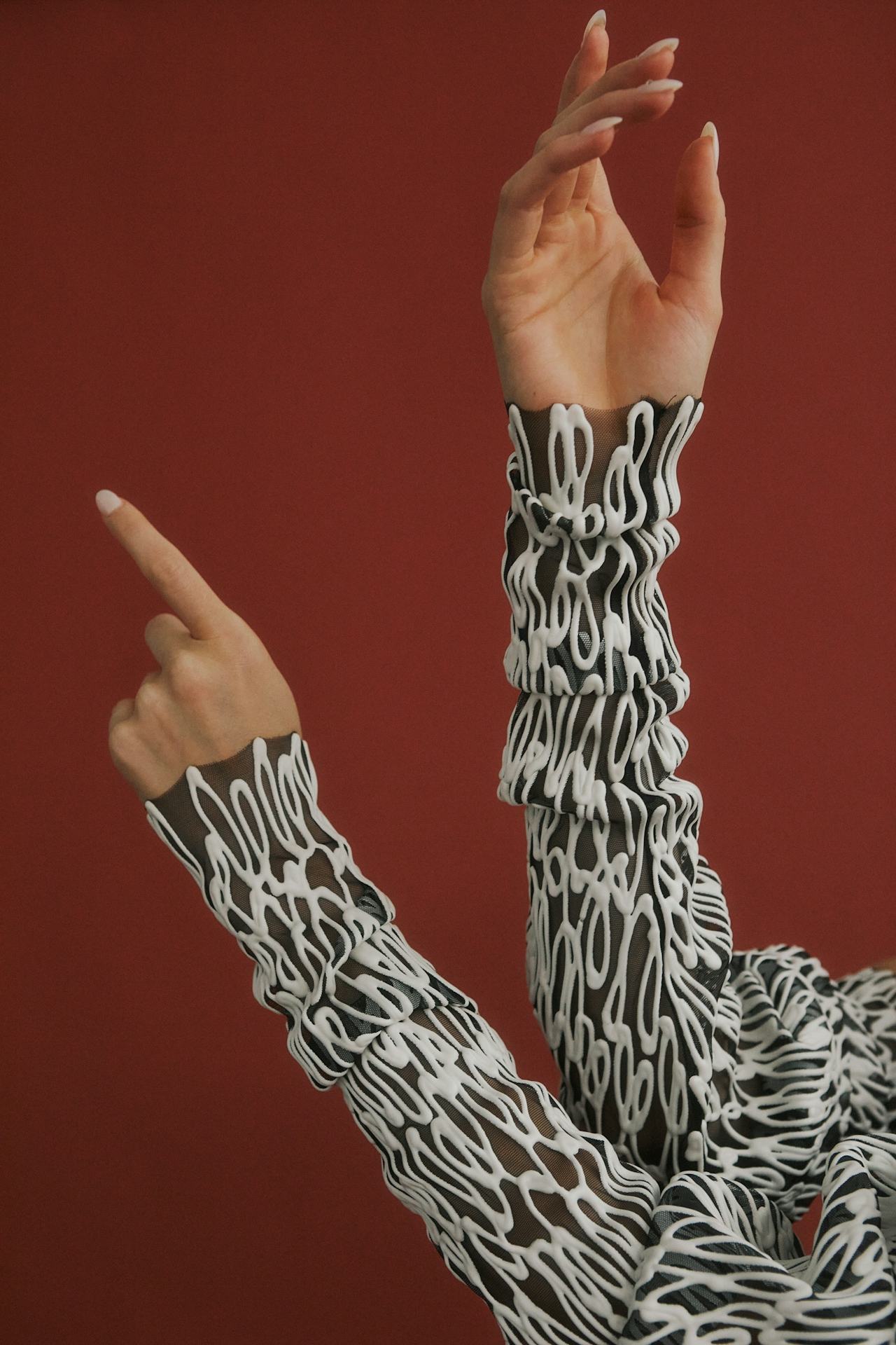 Hands raised, wearing textured sleeves